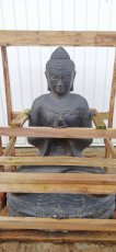 boeddha zit en bid in natuursteen